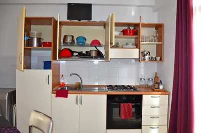 a small kitchen with white cabinets and a sink at Central Apartamento Fogo 101 in Santa Maria