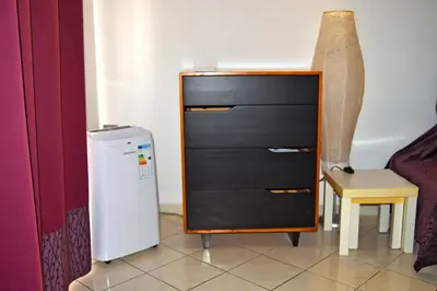 a small refrigerator next to a chair and a dresser at Central Apartamento Fogo 101 in Santa Maria