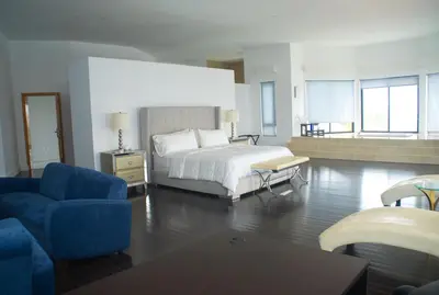 a large bedroom with a bed and a blue couch at The View Hotel CV in São Filipe