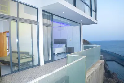 a house with a balcony with a view of the ocean at The View Hotel CV in São Filipe