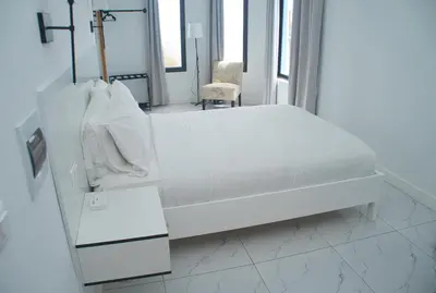 a hospital room with a white bed and a chair at The View Hotel CV in São Filipe