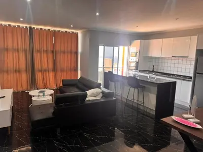 a living room with a couch and a kitchen at Apartamento mais Carro George Mendes in Praia