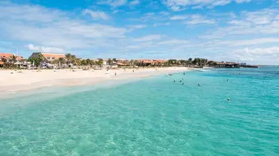 a group of people swimming in the ocean on a beach at Sea Breeze Apartment in Santa Maria