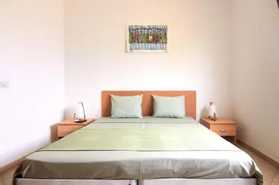 a bedroom with a large bed with two night stands at Sea Breeze Apartment in Santa Maria