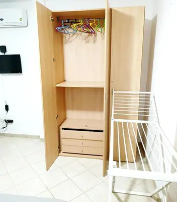 a room with a closet with wooden cabinets and a staircase at Sea Breeze Apartment in Santa Maria