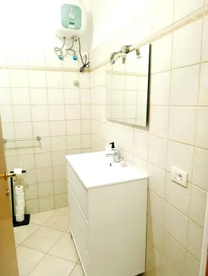 a bathroom with a white sink and a mirror at Sea Breeze Apartment in Santa Maria