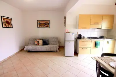 a kitchen with a couch and a white refrigerator at Sea Breeze Apartment in Santa Maria