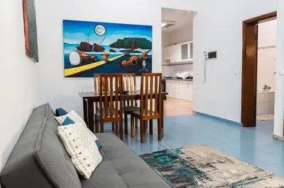 a living room with a couch and a table at Palmarejo, Apartamento T1, frente Praça Center in Praia