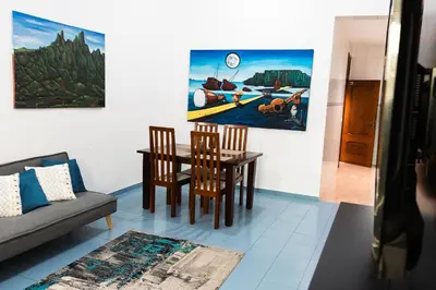 a living room with a dining room table and chairs at Palmarejo, Apartamento T1, frente Praça Center in Praia