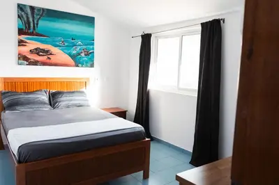 a small bedroom with a bed and a window at Palmarejo, Apartamento T1, frente Praça Center in Praia