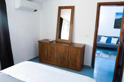a bedroom with a wooden dresser and a mirror at Palmarejo, Apartamento T1, frente Praça Center in Praia
