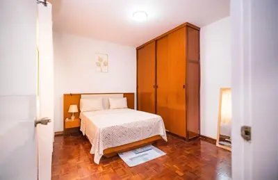 a bedroom with a bed and a wooden cabinet at Cozy and beautiful apartment! in Praia