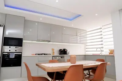 a kitchen with a table and chairs and a blue ceiling at Spacious 3-Bedroom Apt Near Kebra Kanela Beach in Praia