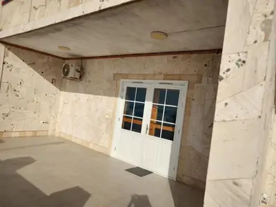 a garage with a white door and a stone wall at Moreira Estates