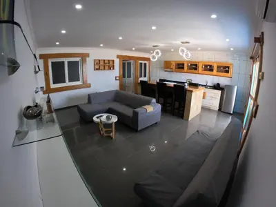 a living room with a couch and a kitchen at Moreira Estates