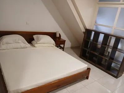 a bed with white sheets and pillows in a room with a window at Paraiso 162E in Santa Maria