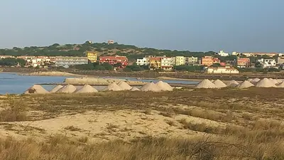 a group of domes on the shore of a body of water at Salina's in Vila do Maio