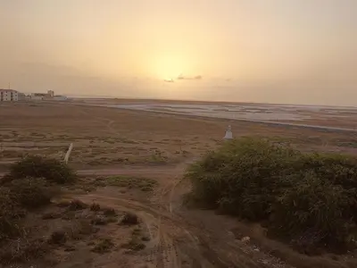 a dirt road in a field with the sunset in the background at Salina's in Vila do Maio