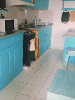 a kitchen with blue cabinets and a black stove at Salina's in Vila do Maio