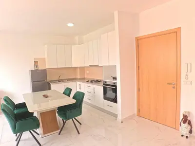a kitchen with a small table and green chairs at Casa Emilie T2, 2 bedrooms in Santa Maria