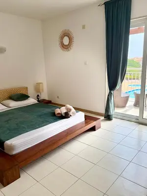 a bedroom with a bed and a large window at Studio with pool in Santa Maria