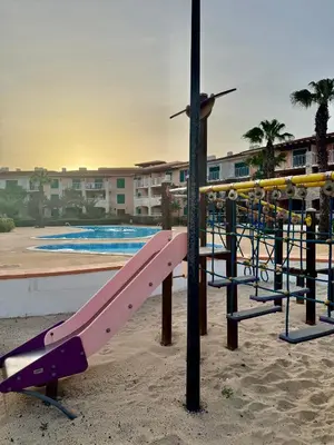 a playground with a pink slide in front of a pool at Studio with pool in Santa Maria