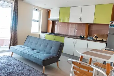 a living room with a blue couch in a kitchen at Apartamento T1 em Palmarejo, Trás de pão quente in Praia