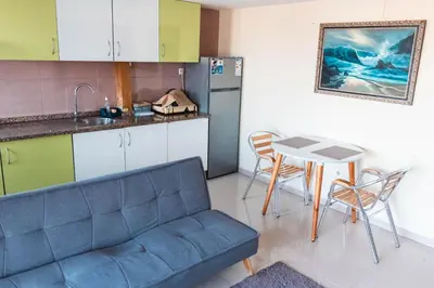 a kitchen with a couch and a table in a kitchen at Apartamento T1 em Palmarejo, Trás de pão quente in Praia