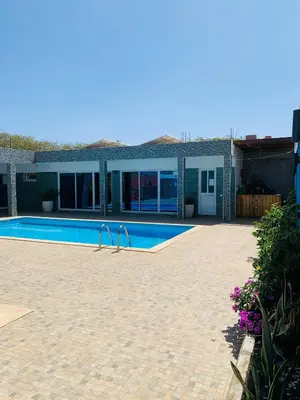 a swimming pool in front of a house at Pousada Aguia in Praia