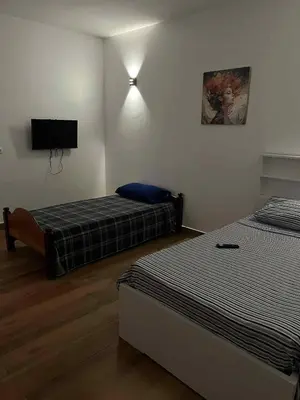 a bedroom with two beds and a flat screen tv at Pousada Aguia in Praia