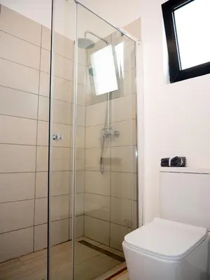 a glass shower in a bathroom with a toilet at Blue Coast Villas - Villa 6 in Cidade Velha