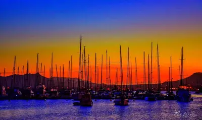 a group of boats in the water at sunset at Mira Mar Mindelo in Mindelo