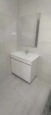 a white bathroom with a sink and a mirror at Mira Mar Mindelo in Mindelo
