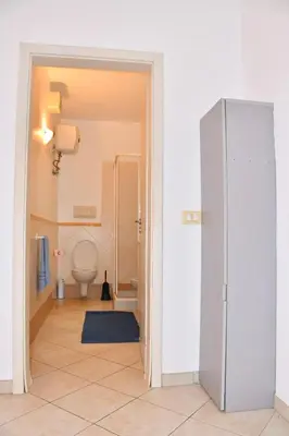 a bathroom with a toilet and a refrigerator at Urban Studio Plaza 6 in Santa Maria