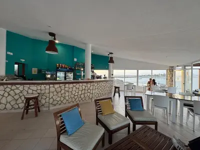 a restaurant with chairs and a bar with the ocean at Murdeira V17 I by RPG Group in Beirona