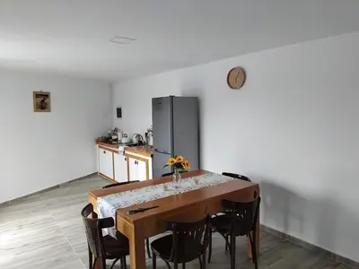 a kitchen with a table with chairs and a refrigerator at Quinta Achada Fazenda in São Tiago