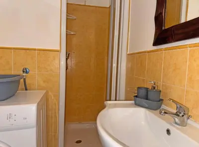 a small bathroom with a sink and a shower at Morabeza Santa Maria - Djadsal Moradias in Santa Maria