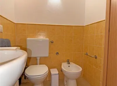 a bathroom with a toilet and a sink and a tub at Morabeza Santa Maria - Djadsal Moradias in Santa Maria