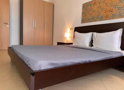 a bedroom with a large bed with a blue comforter at Morabeza Santa Maria - Djadsal Moradias in Santa Maria