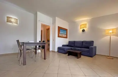 a living room with a blue couch and a table at Morabeza Santa Maria - Djadsal Moradias in Santa Maria