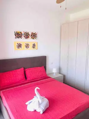a bedroom with a red bed with a white swan on it at Kite & Chill Sal Rei in Sal Rei