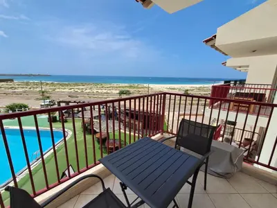a balcony with a bench and a swimming pool at Boa Vista BriMar Holidays, apartamento with pool in Rabil
