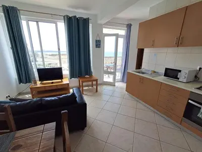 a living room with a couch and a kitchen at Boa Vista BriMar Holidays, apartamento with pool in Rabil