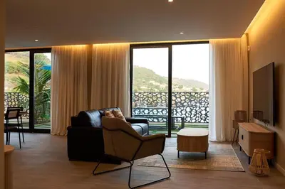a living room with a couch and a chair and a television at CORAL BAY - Kode Villa in Cidade Velha