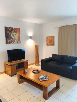 a living room with a blue couch and a coffee table at HostySpot - Vila Verde Resort in Santa Maria