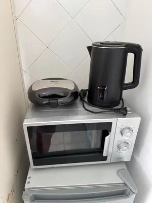 a microwave with a coffee pot on top of it at Murdeira V 17 J by RPG Group in Beirona