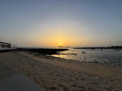 a sunset on a beach with the sun setting at Murdeira V 17 J by RPG Group in Beirona