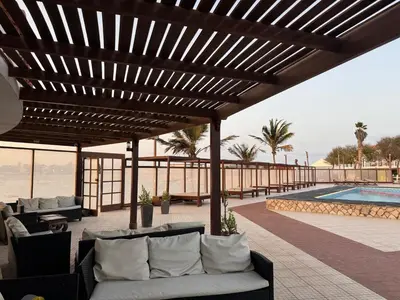a wooden pergola with couches and a swimming pool at Murdeira V 17 J by RPG Group in Beirona