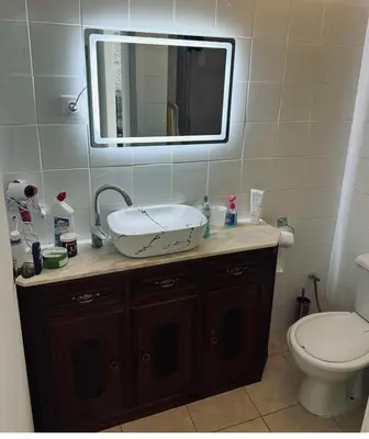 a bathroom with a sink and a toilet and a mirror at Condominio Finaçon praia ilha santiago in Prainha