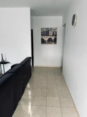 a hallway with black furniture and a white wall at Condominio Finaçon praia ilha santiago in Prainha